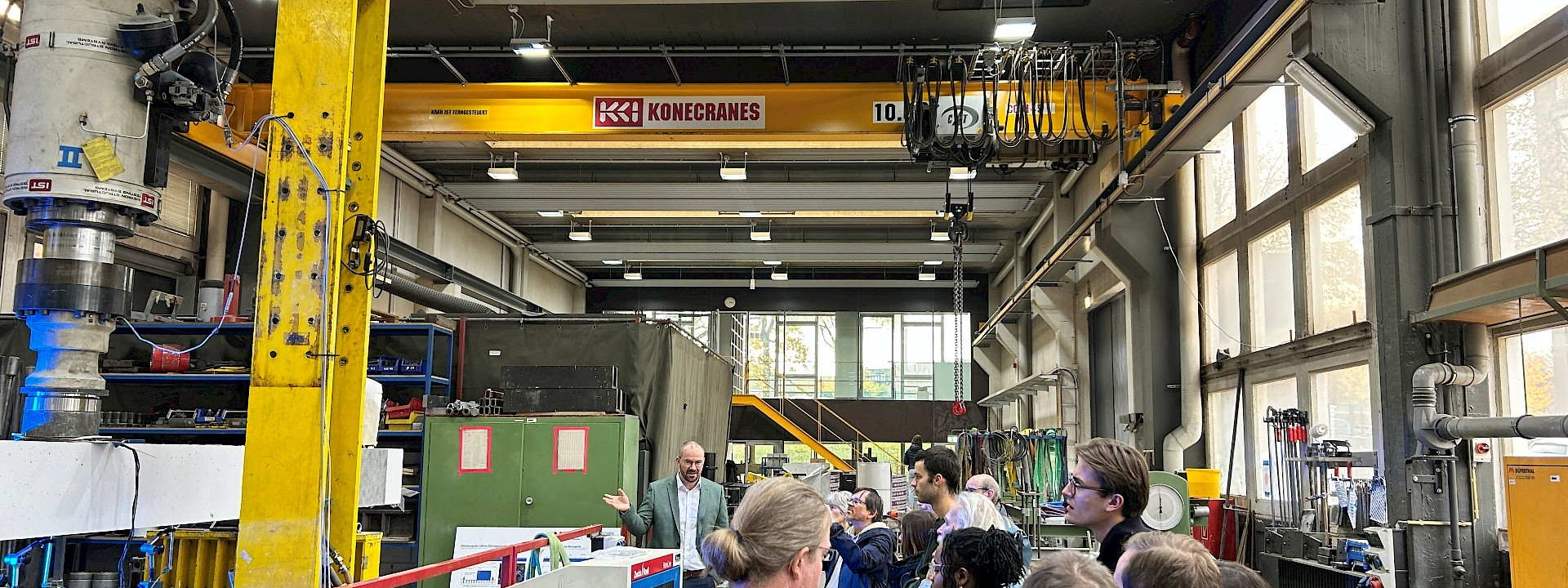 a visiting group in a laboratory hall looking at the test bench